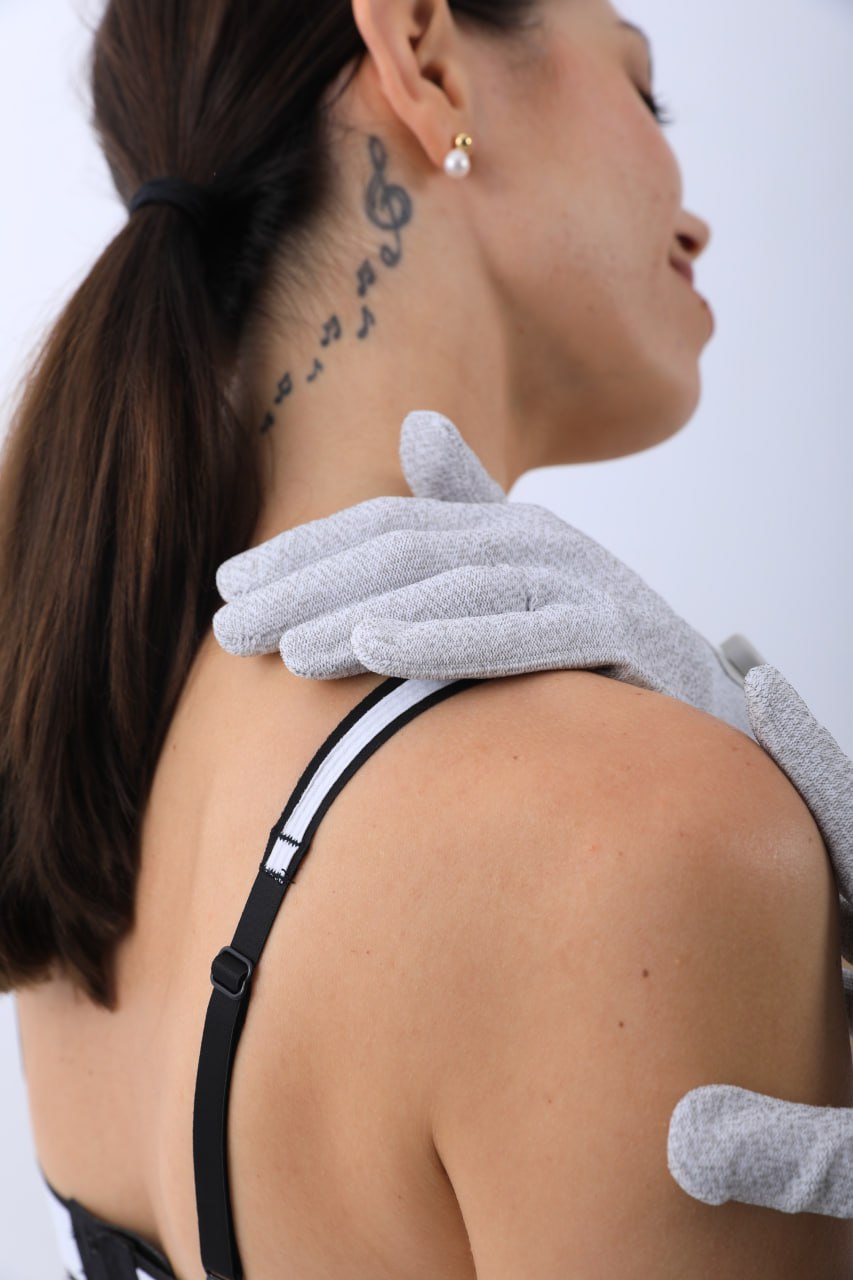 Woman receiving a massage with bioenergetic gloves, showcasing relaxation techniques and wellness benefits.